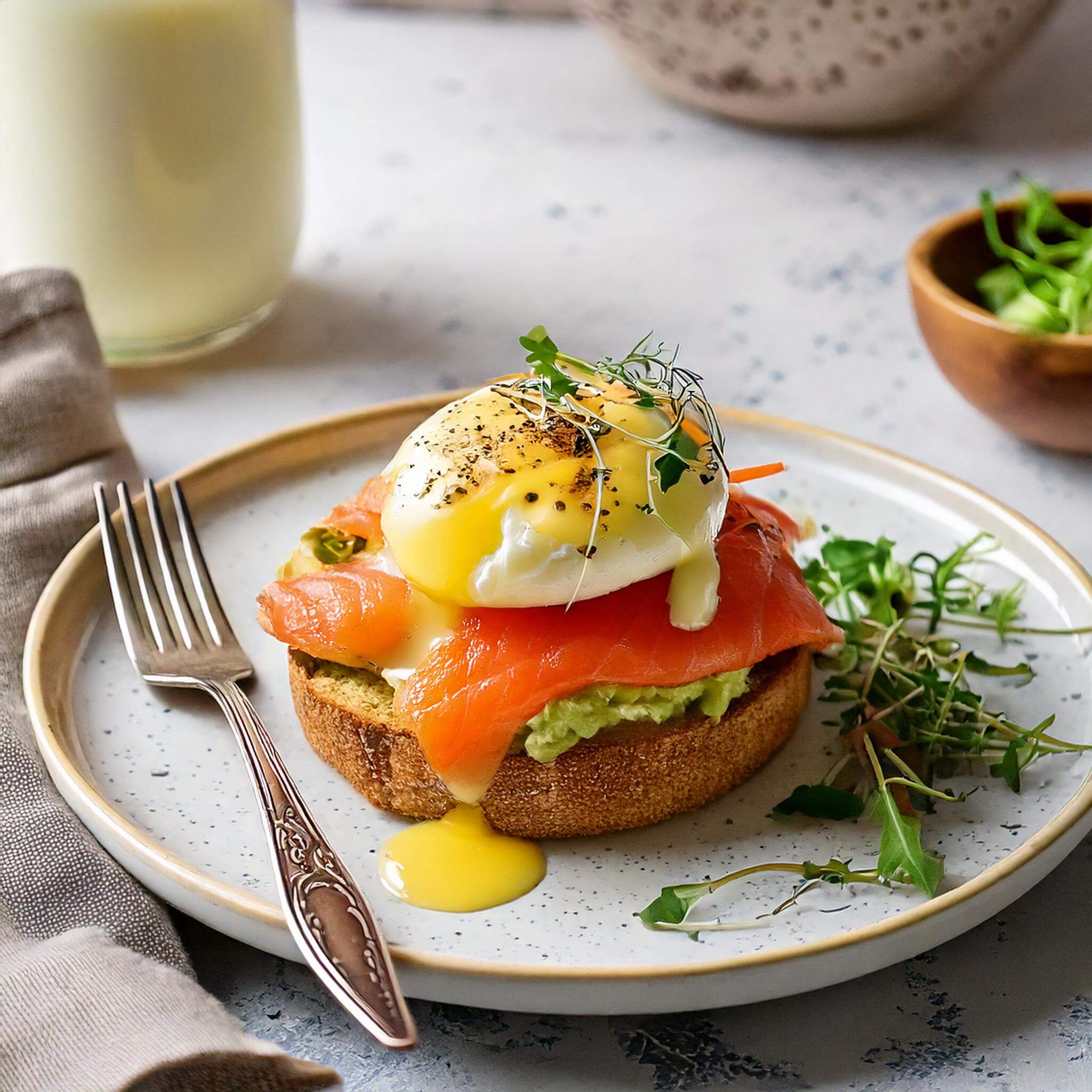 Final presentation of Smoked Salmon and Avocado Eggs Royale on a plate.