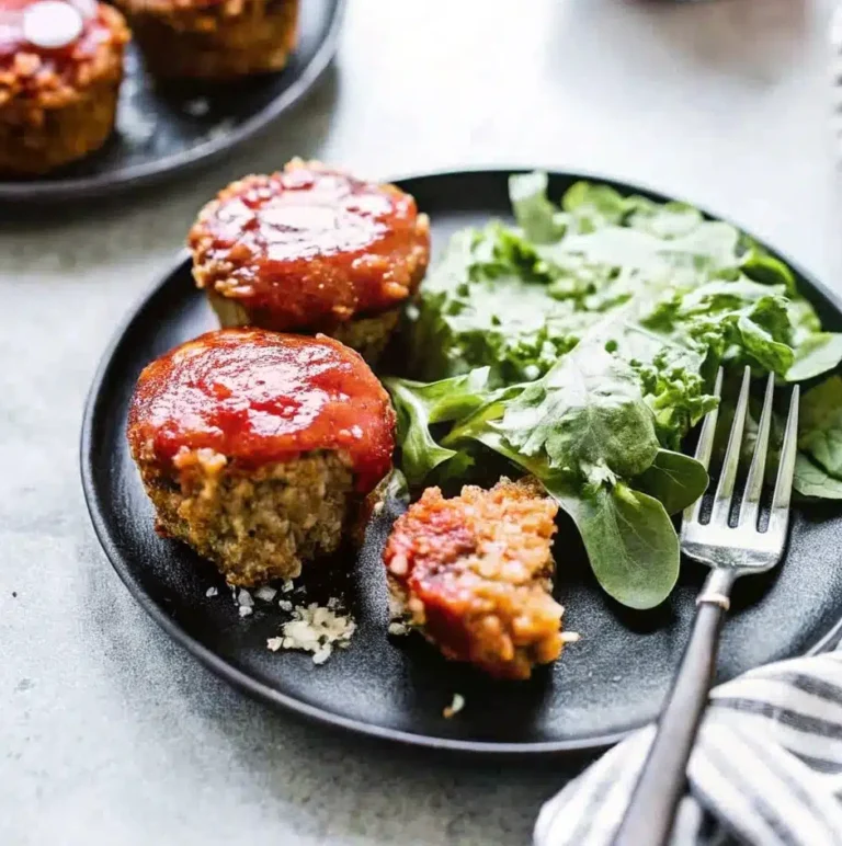 Freshly baked mini meatloaf muffins with a caramelized glaze, served with a side of tangy sauce