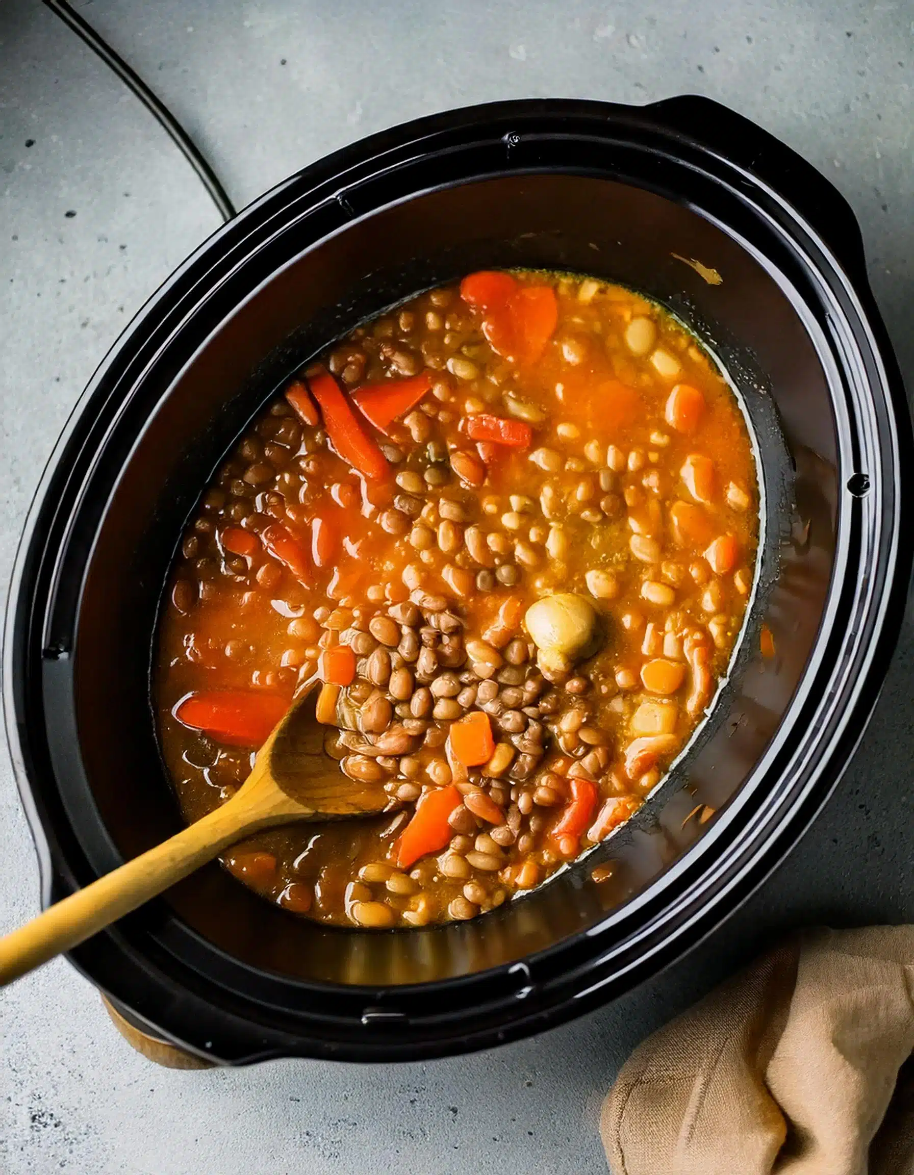 Slow cooker lentil soup with carrots and garlic.